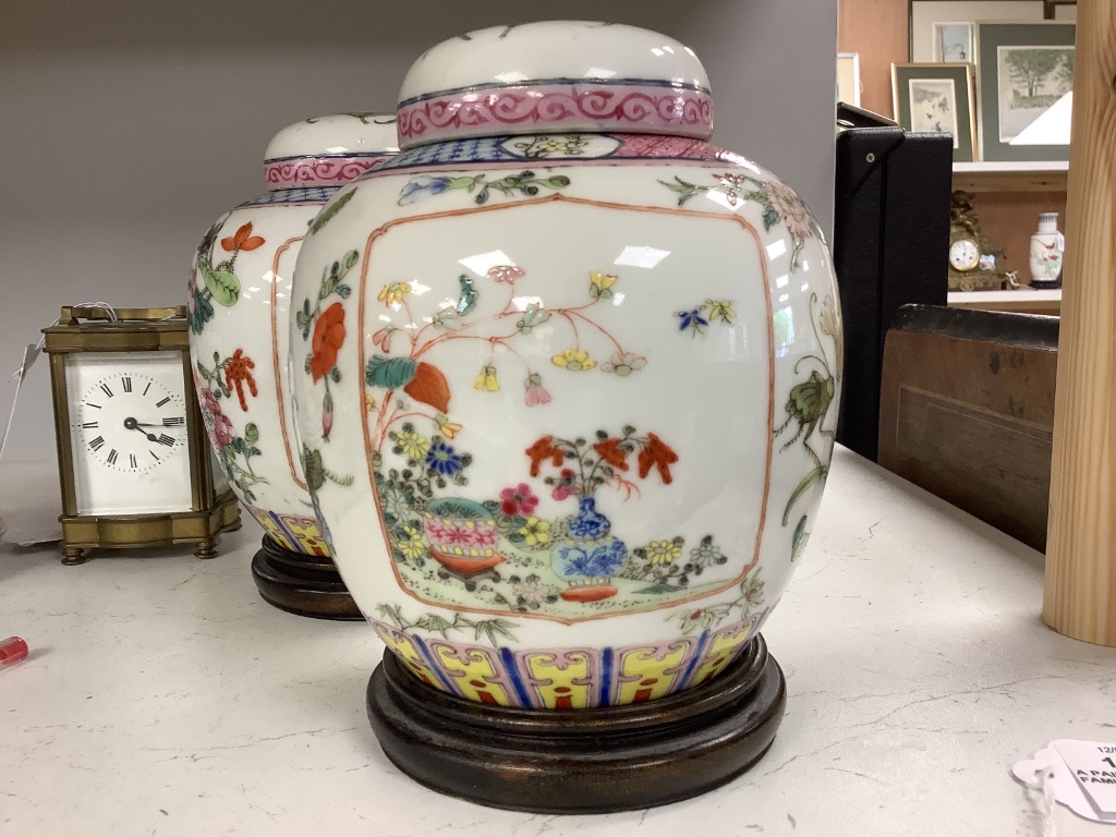 A pair of Chinese famille rose jars and covers, late 19/early 20th century, 15.5cm, on hardwood stands